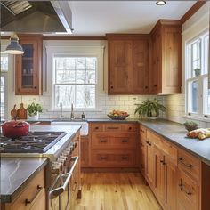 a large kitchen with wooden cabinets and stainless steel appliances, along with wood flooring