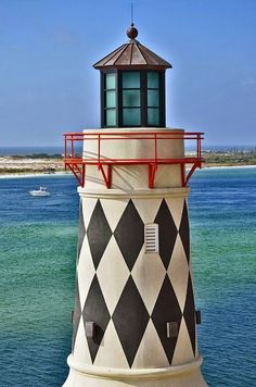 the lighthouse is painted black and white with a red trim around it's top