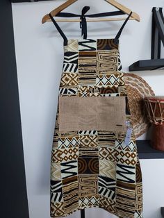 "Make your kitchen beautiful with this handmade African Print Apron with Pocket. Crafted from 100% cotton, this apron features a colorful fabric, deep pockets, and fits US sizes 6-12. Plus, the fabric retains its vibrant color even after washing. Make cooking fun with this signature piece that will add joy, color, and life to your kitchen. Handmade with durable 100% Cotton Fabric. Retains colour after multiple washes Handmade African Print Apron | Traditional African \"Bogolan\" Print Apron Mash