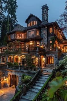 a large house with stairs leading up to it's second story and lights on