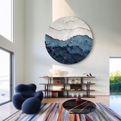 a living room filled with furniture and a large round painting on the wall above it