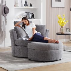 a woman sitting in a chair with her feet up on the arm rest and reading a book