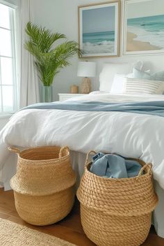 two baskets are sitting on the floor in front of a bed with white linens