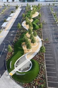 an aerial view of a parking lot with lots of grass and trees on each side