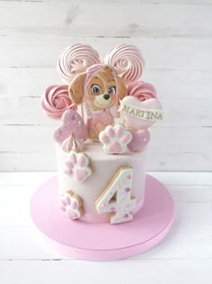 a birthday cake for a girl with a dog on top and pink icing around it