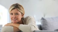 a woman sitting on top of a gray couch