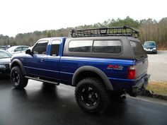 a blue pick up truck parked in a parking lot