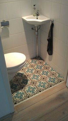 a white toilet sitting next to a sink in a bathroom