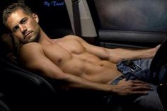 a shirtless man laying in the passenger seat of a car