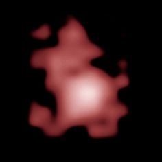 a blurry image of a red object in the dark with light coming from it