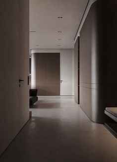 an empty hallway with black furniture and white walls