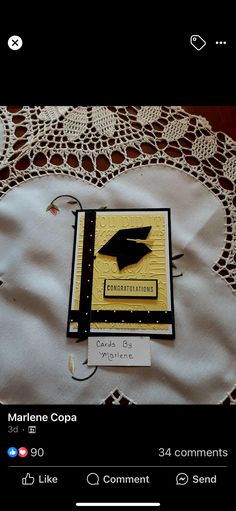 a book with a graduation cap on it sitting on top of a lace doily