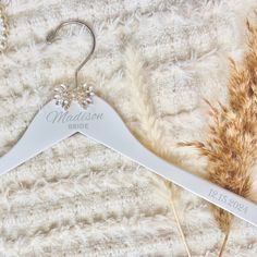 a wedding dress hanger with the name madison bride on it next to some dried grass