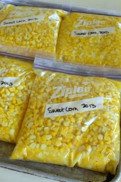 four bags of sweet corn sitting on top of a counter