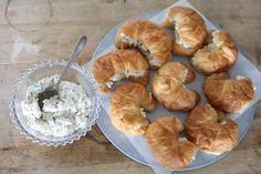 croissants with cream cheese on a plate next to a bowl of dip