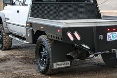 a white truck parked on top of a dirt field