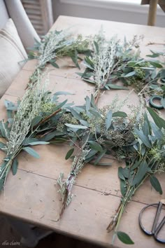 the table is covered with greenery and scissors