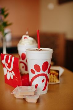 there are two cups on the table and one has a straw in it