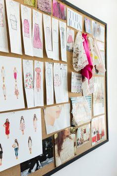 a bulletin board with pictures and clothes hanging on it