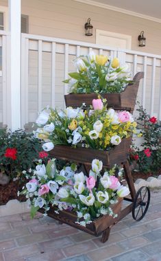 three tiered wooden planter with flowers in it on the side of a house