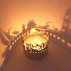 a candle that is sitting in the middle of a room with some shadows on it