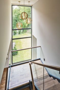 an open staircase with glass railing and wooden handrails leading up to the second floor