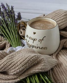 a cup of hot chocolate next to some flowers