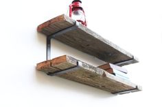 two wooden shelves with one shelf holding a bottle and the other hanging on a wall