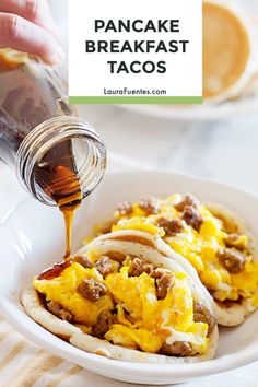 someone is pouring syrup on some breakfast tacos