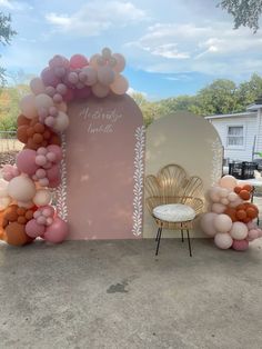 an arch made out of balloons with a chair and table in the background at a wedding