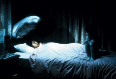 a person laying on a bed in the dark