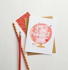 a card that says you are the world to me and two pencils next to it