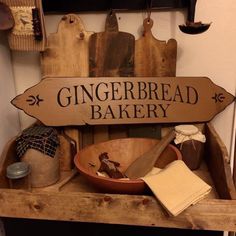 a wooden sign that says gingerbread bakery on top of a table with bowls and utensils