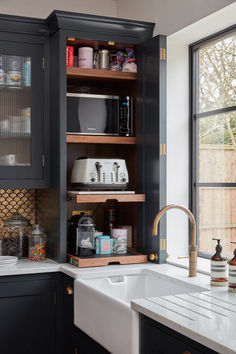 a kitchen with black cabinets and white counter tops