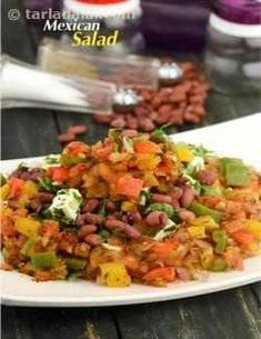 a white plate topped with beans and veggies on top of a wooden table