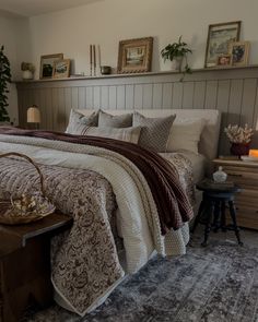 a bedroom with a bed, nightstands and pictures on the wall