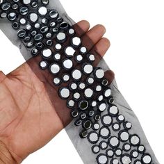 a hand is holding something with black and white dots on it