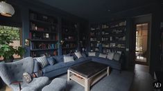 a living room filled with blue couches and bookshelves