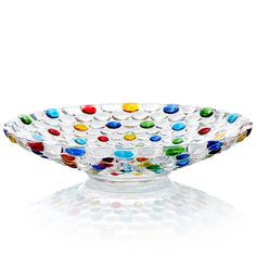 a glass bowl with multi colored dots on it