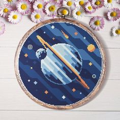 the cross stitch pattern is in progress to make it look like an outer space scene