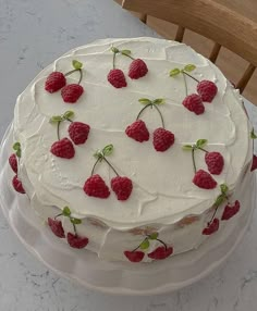 a cake with white frosting and raspberries on it