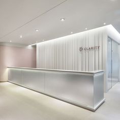 an empty white reception area with lights on the ceiling and glass partitions to the wall