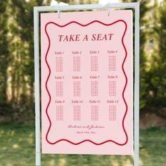 a pink sign with red writing that says take a seat