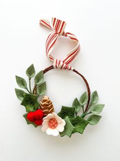 a christmas wreath made out of felt and fabric with red, white and green decorations