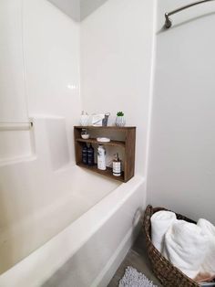 a white bath tub sitting next to a wooden shelf