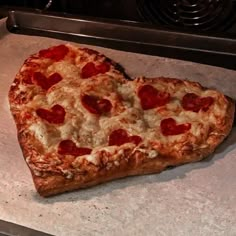 a heart shaped pizza sitting on top of a pan