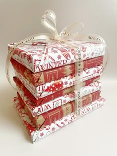 a stack of red and white books wrapped in ribbon