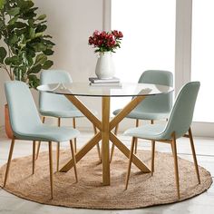 a glass table with four chairs around it and a potted plant in the corner