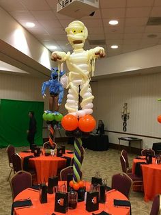 an inflatable skeleton is on top of a table with orange and green decorations