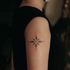 a woman's arm with a small star tattoo on the left side of her arm